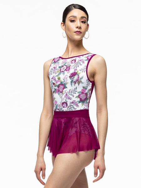 Model is wearing magenta mini mesh skirt with wide waistband. Paired with white and magenta floral print leotard.