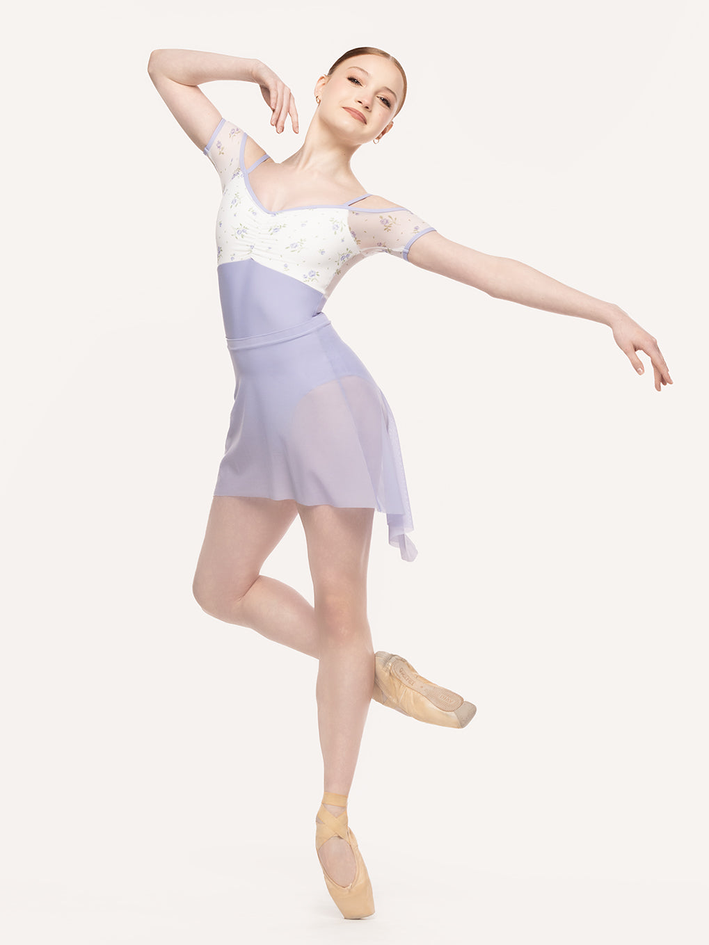 Eleve Dancewear Mid High-Low Skirt  Mesh in  Lavender color, front view of dancer on cou-de-pie on point.