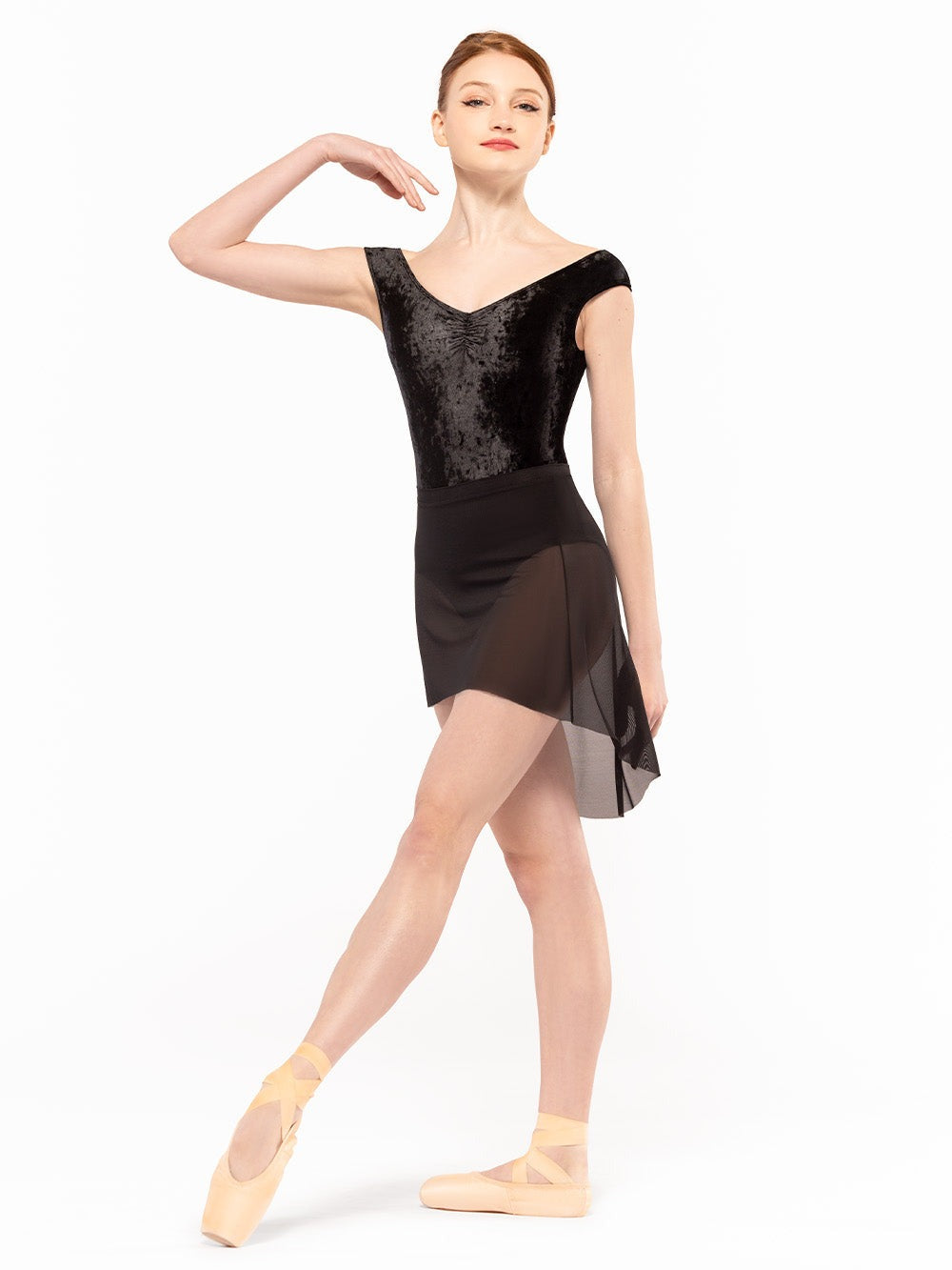 Dancer is facing front with one leg on tendu crossed front and one hand on the shoulder, wearing Sophia Leotard Black Crushed Velvet RTW.
