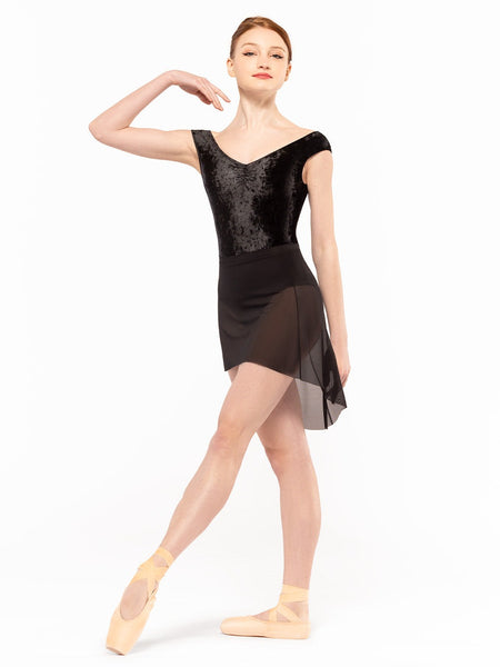 Dancer is facing front with one leg on tendu crossed devant and one arm to the shoulder, wearing a Mid High-Low Skirt Black Mesh RTW.