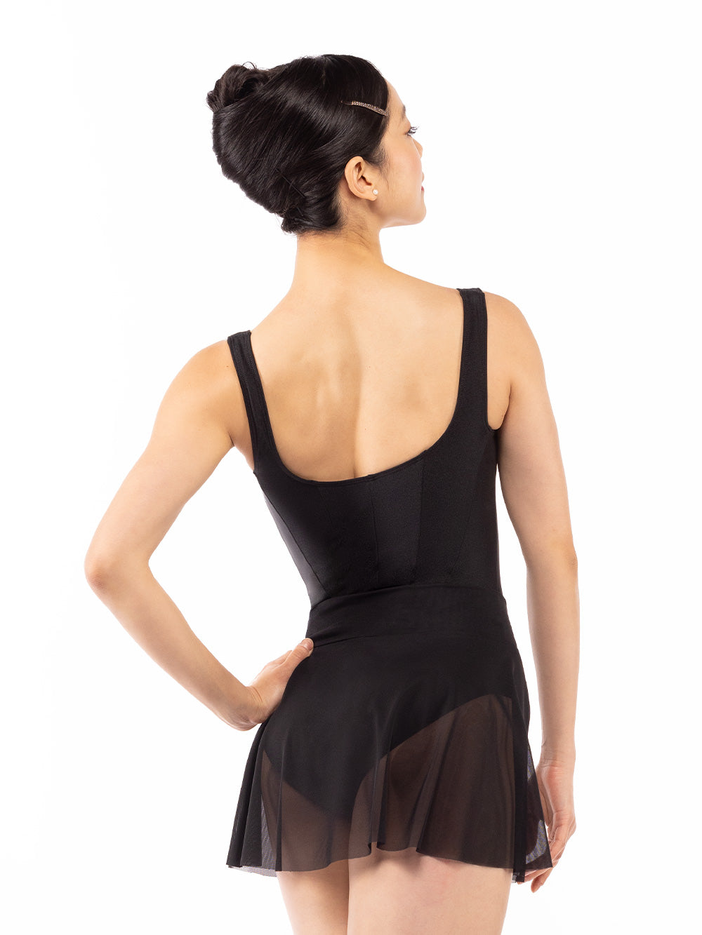Dancer face back with one hand on the hip, wearing Amora Skirt Black Mesh RTW.