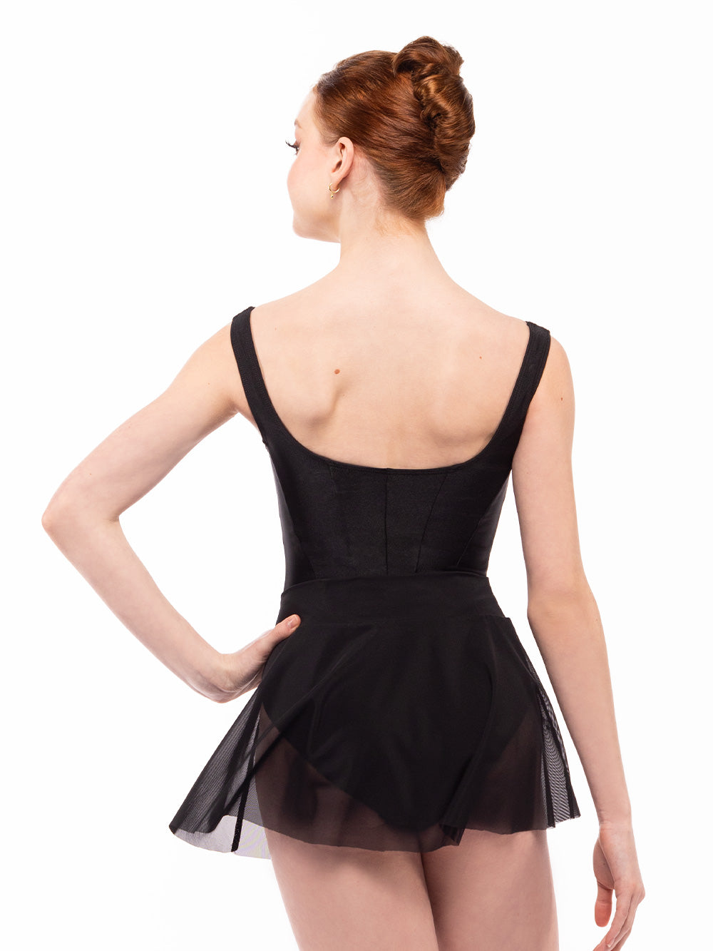 Dancer face back with one hand on the hip, wearing Amora Skirt Black Mesh RTW.