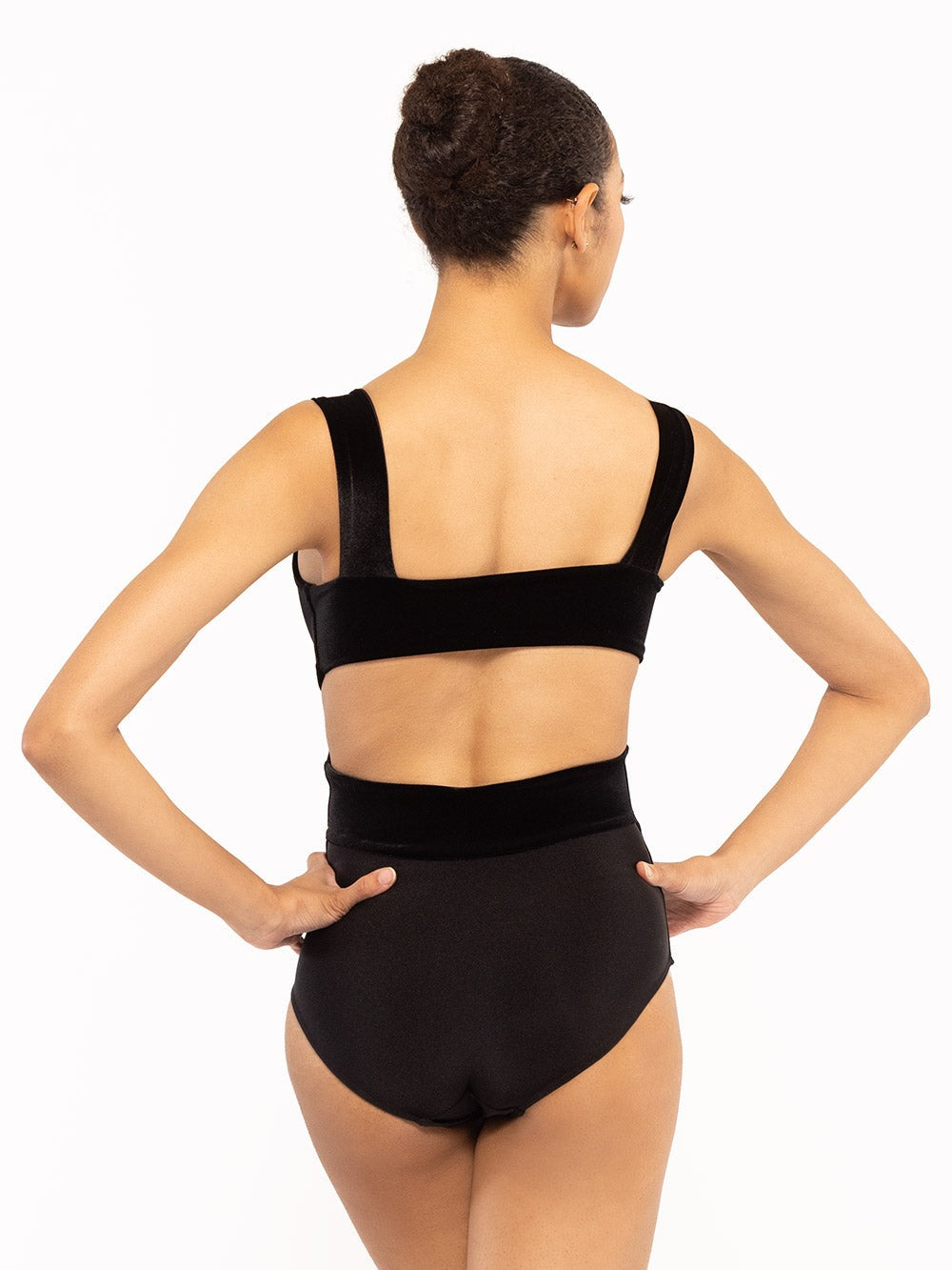 Dancer is facing back with both hands on the hip, wearing a Jackie Leotard Black Velvet RTW.