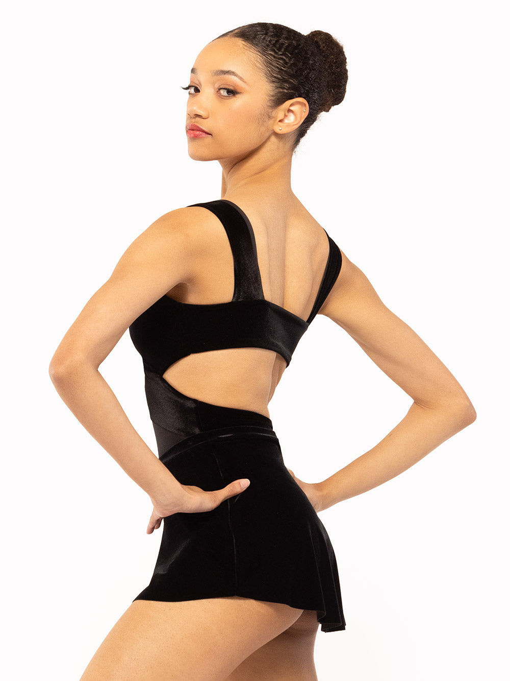 Dancer is facing profile but showing back with both hands on each hips, wearing Jackie Leotard Black Velvet RTW.