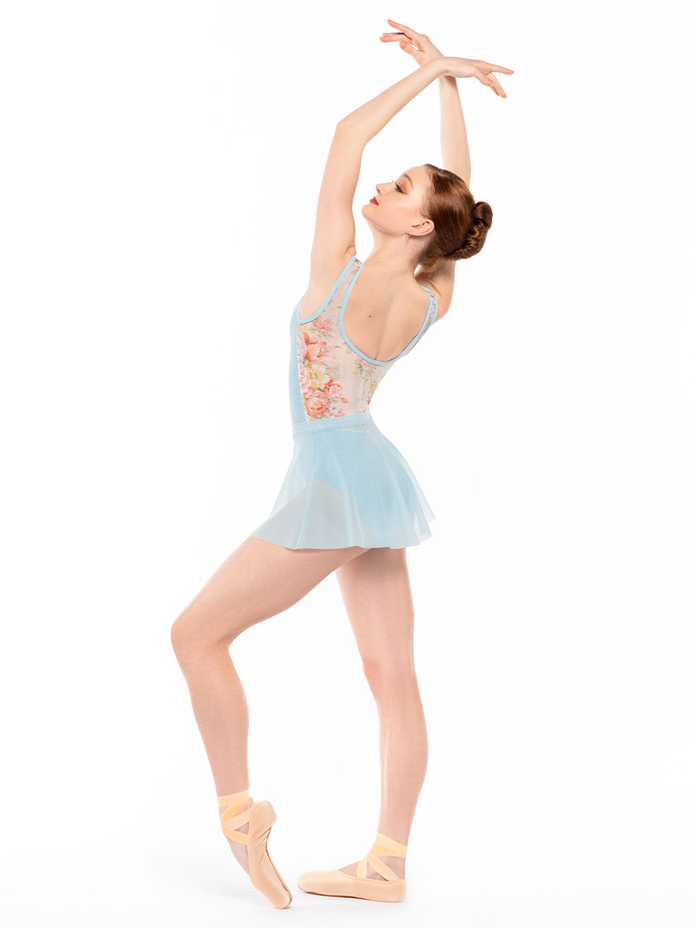 Dancer is profile with one leg on point resting close in front and arms crossed in fifth position, wearing a Flare Skirt Blue Star Mesh RTW
