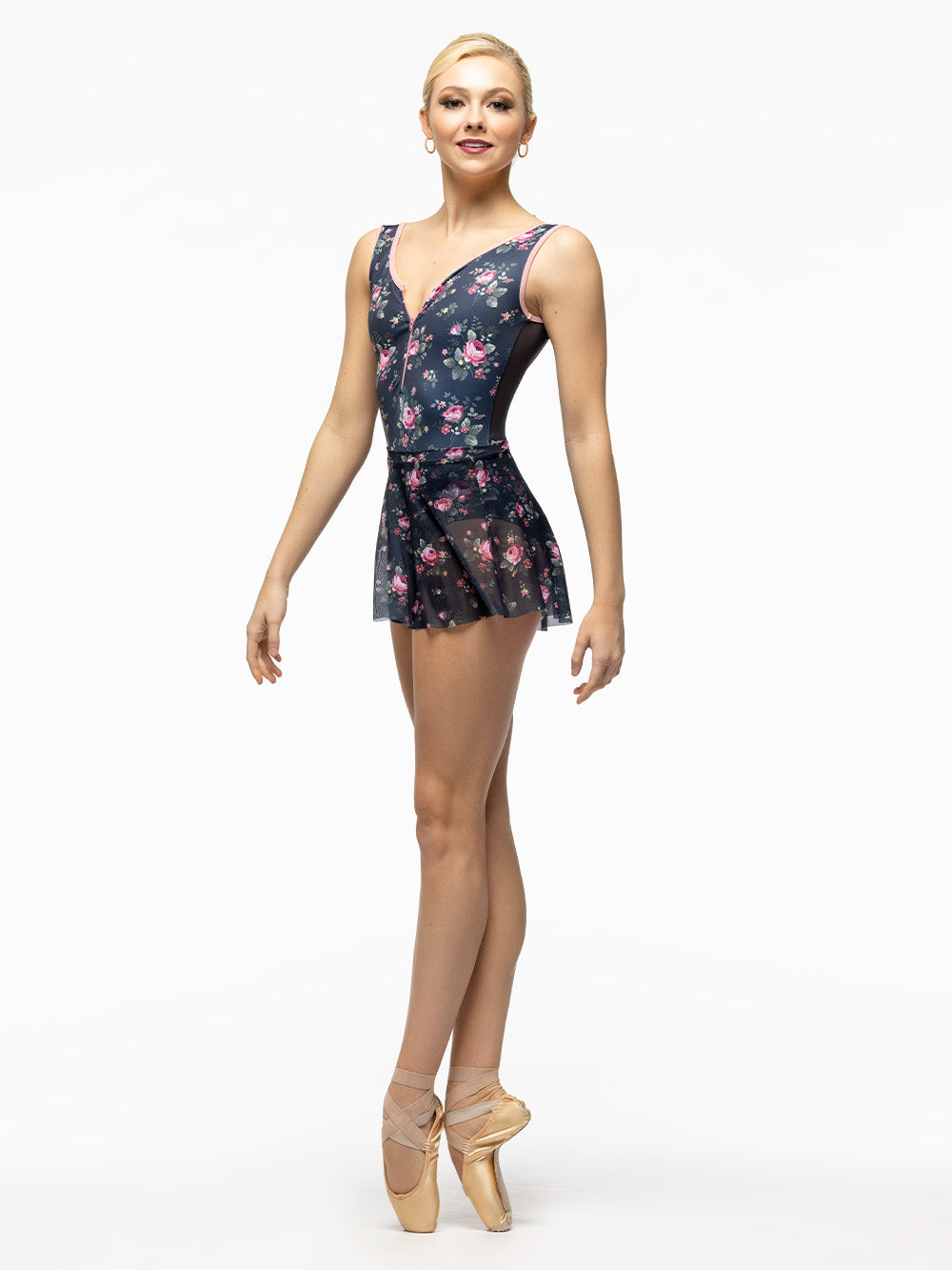 Model is wearing navy blue and pink floral print bodysuit with zipper front, tank straps, and gray mesh scoop back. Paired with matching short floral mesh skirt.