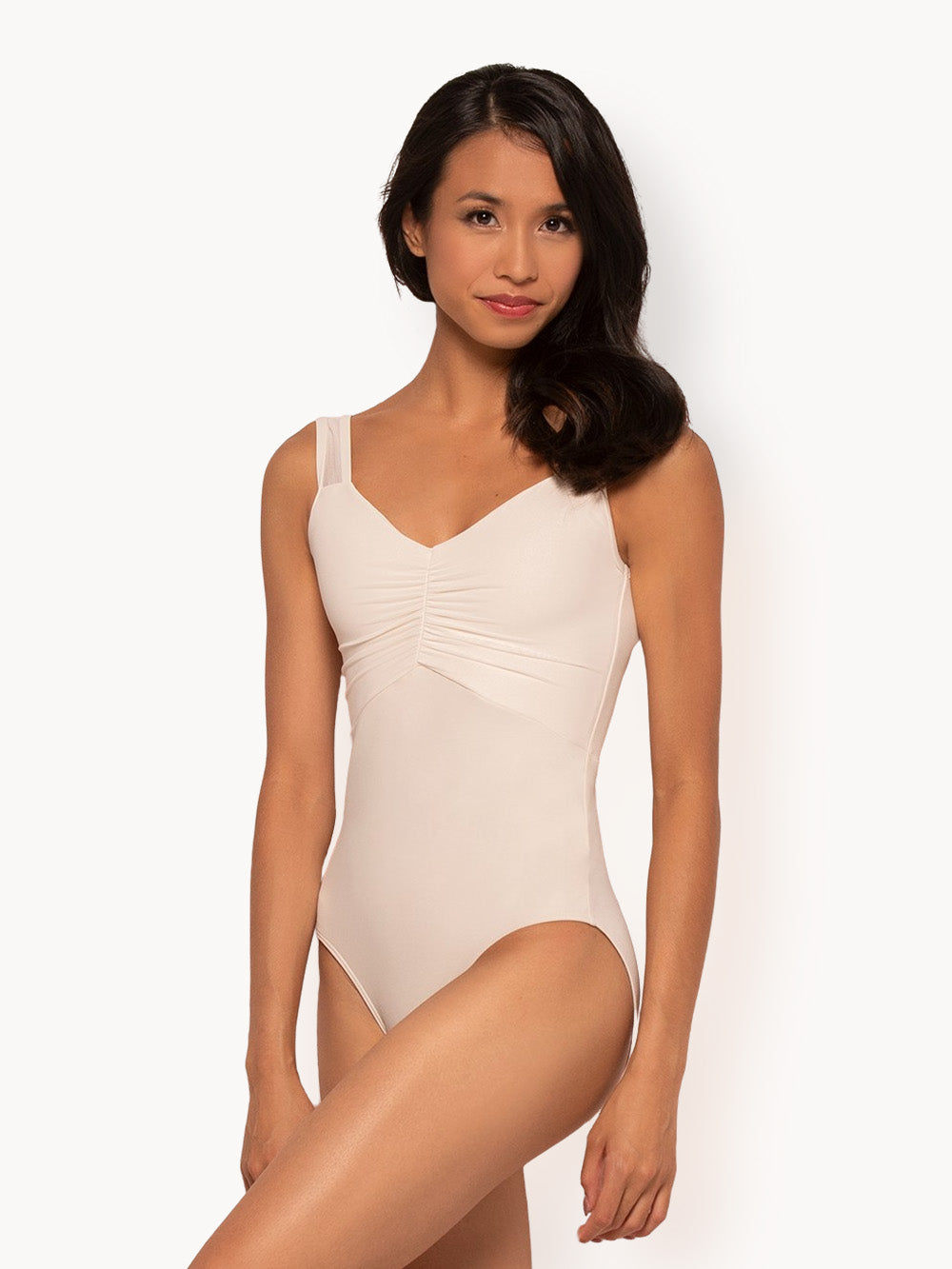 Facing front with arms relaxed down, dancer is wearing a Beatrice Leotard Cream RTW.