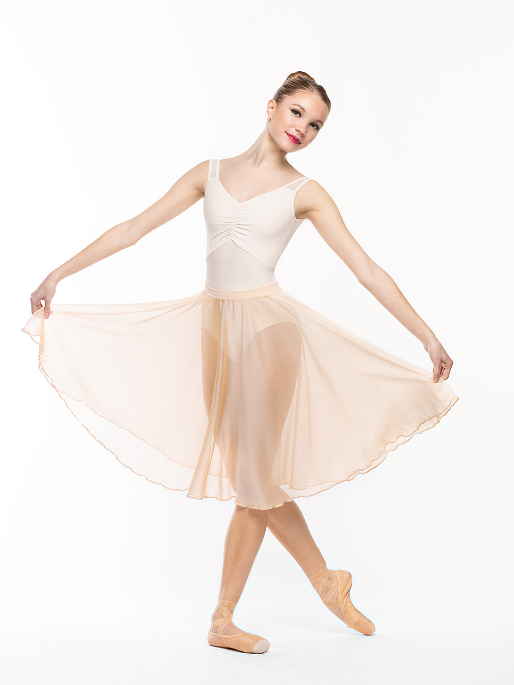 Dancer is facing front holding a skirt to the side on cou-de-pie derriere, wearing a Beatrice Leotard Cream RTW.