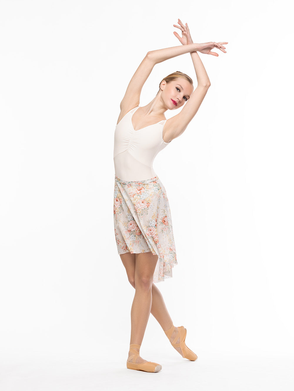 Dancer is facing front on cou-de-pie flat derriere and arms crossed on fifth position, wearing a Beatrice Leotard Cream RTW.