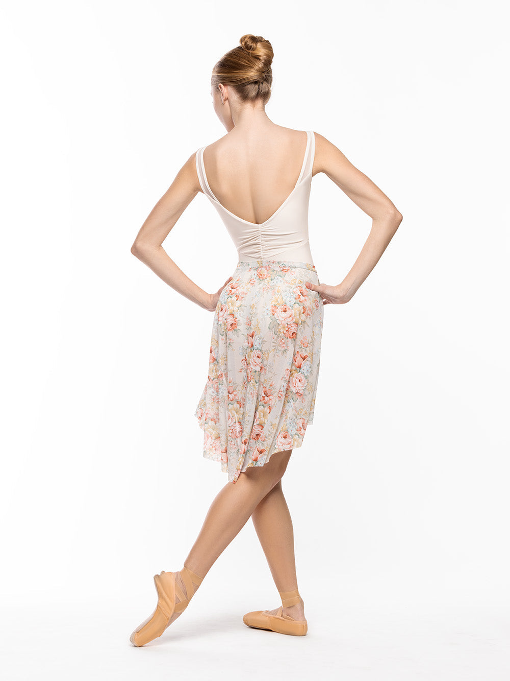 Dancer is facing back with both arms on the hips and one leg on cou-de-pie flat derriere, wearing a Beatrice Leotard Cream RTW.