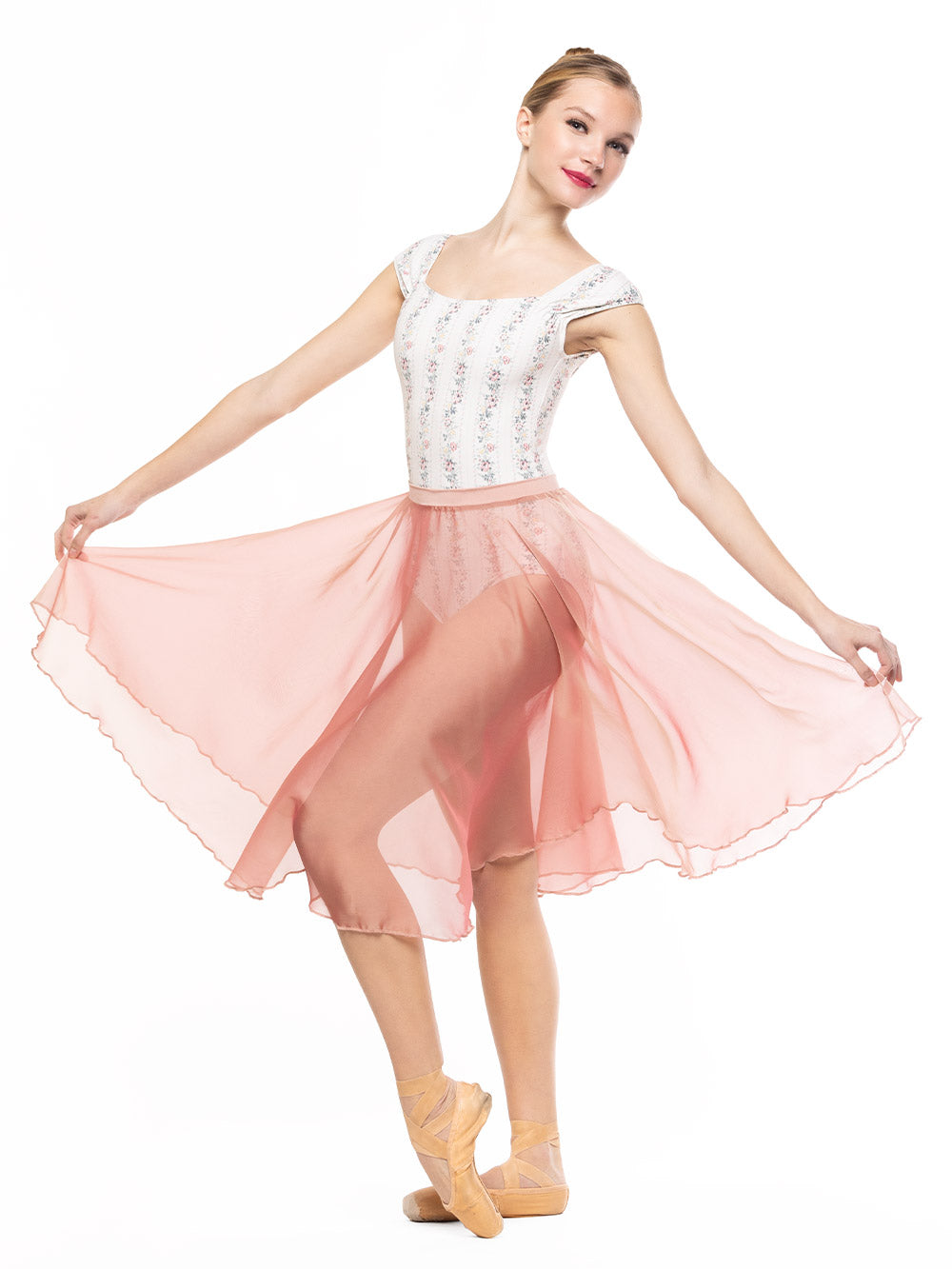Detail of the Chiffon Rehearsal Skirt Sandstone RTW while dancer has both arms holding it on the sides, and one leg on point crossed on front.