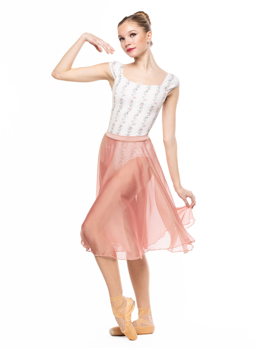 Dancer is facing front with one arm on the shoulder and one leg crossed on point, wearing a Chiffon Rehearsal Skirt Sandstone RTW.