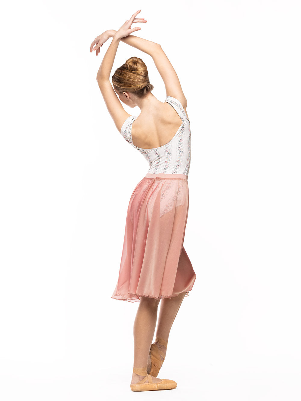 Dancer is facing back with both arms crossed on fifth position with one leg crossed on point bend, wearing a Chiffon Rehearsal Skirt Sandstone RTW.