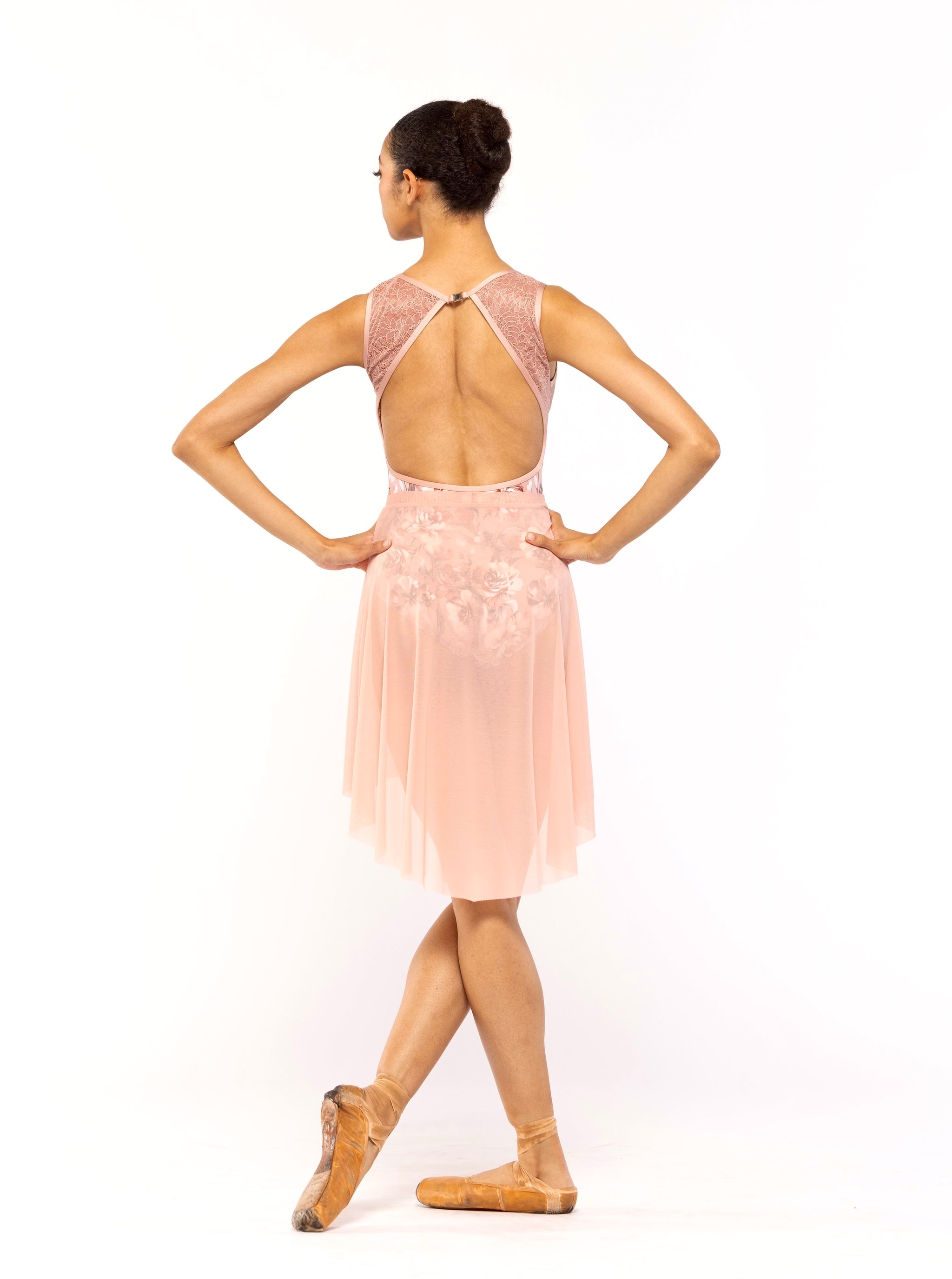 Dancer is facing back with both arms on the hips, wearing a Back Tuck Skirt Rosewater Mesh RTW.