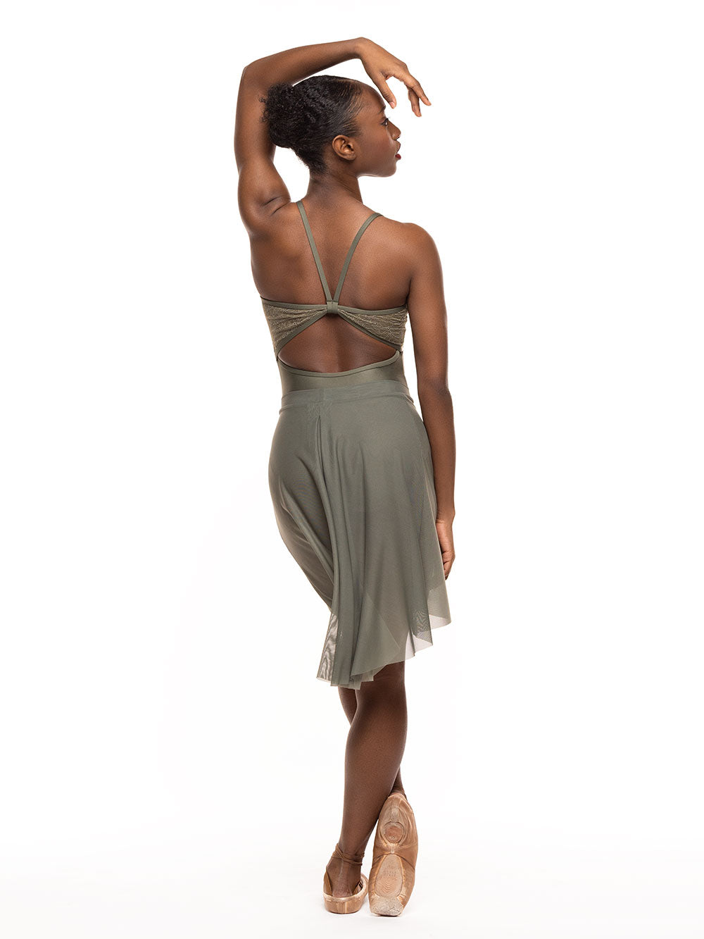 Dancer is facing back with one arm resting over the head and one lead wrapping the other one in front, wearing a Back Tuck Skirt Dusty Olive Mesh RTW.