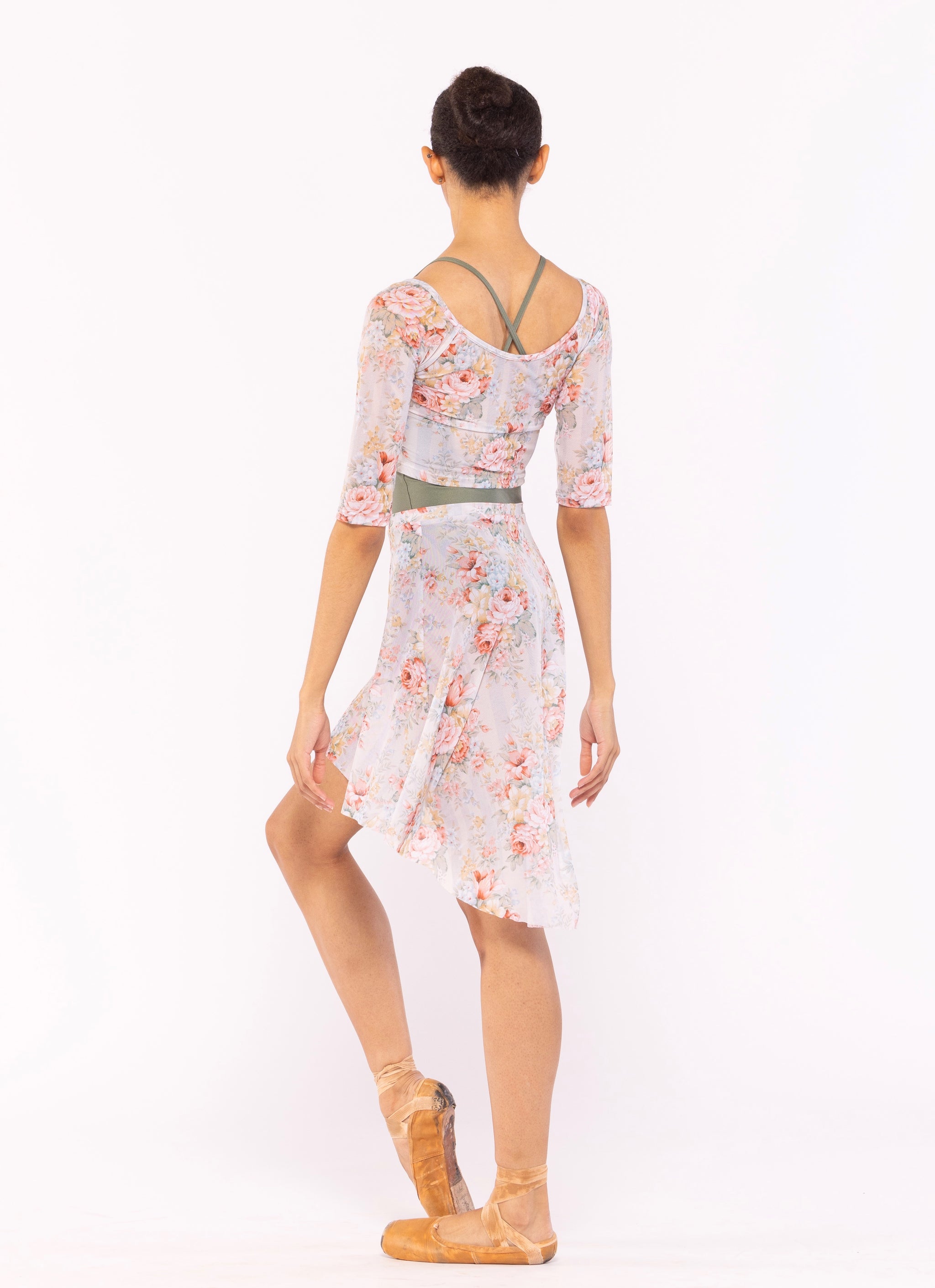 Dancer is facing back with both arms resting down and one leg on point also resting close, wearing a Long High-Low Skirt Endless Love Mesh RTW.
