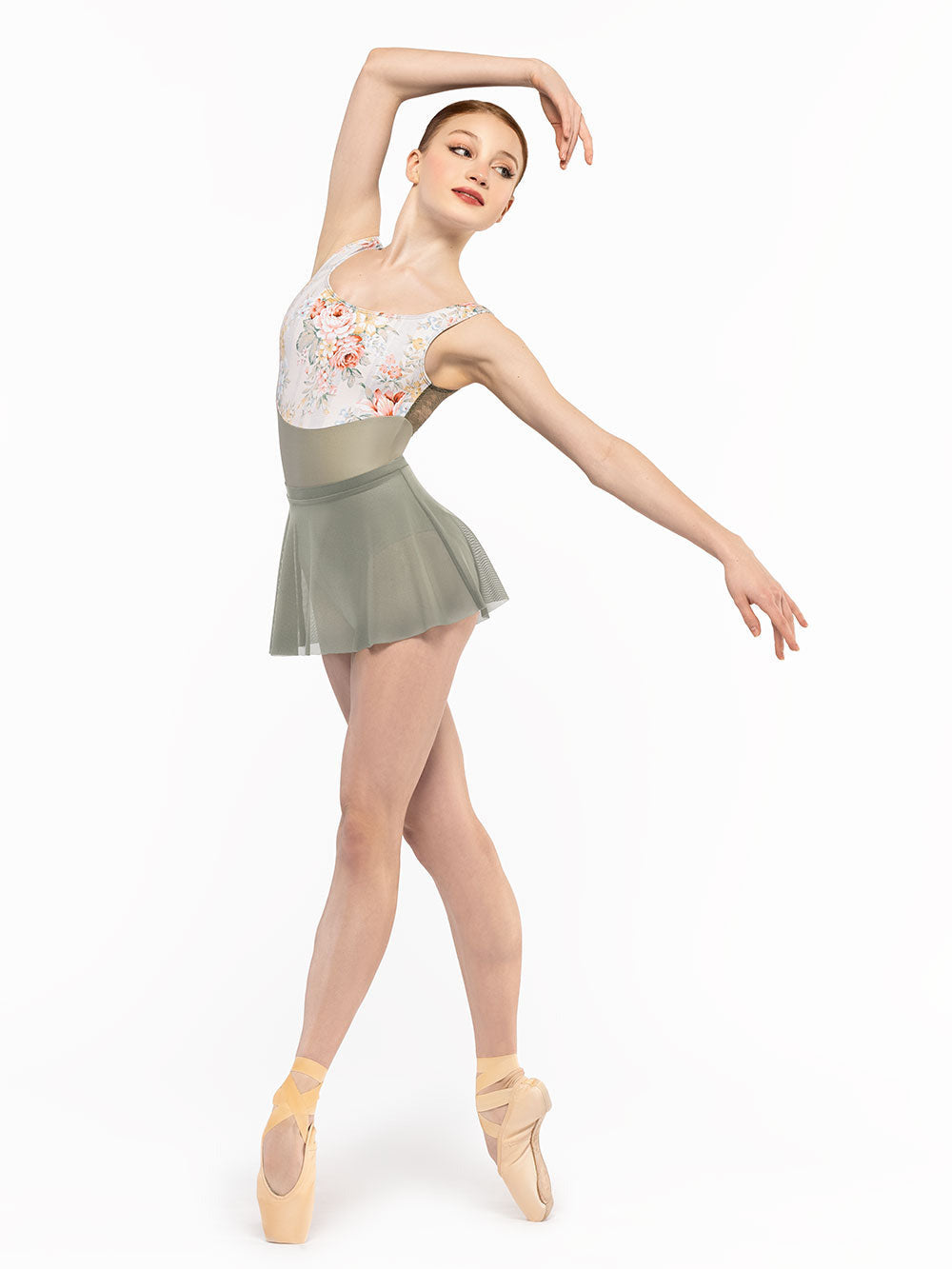 Dancer is facing front but on point in four crossed to the diagonal with one arm over the head, wearing a Flare Skirt Mercury Mesh RTW.