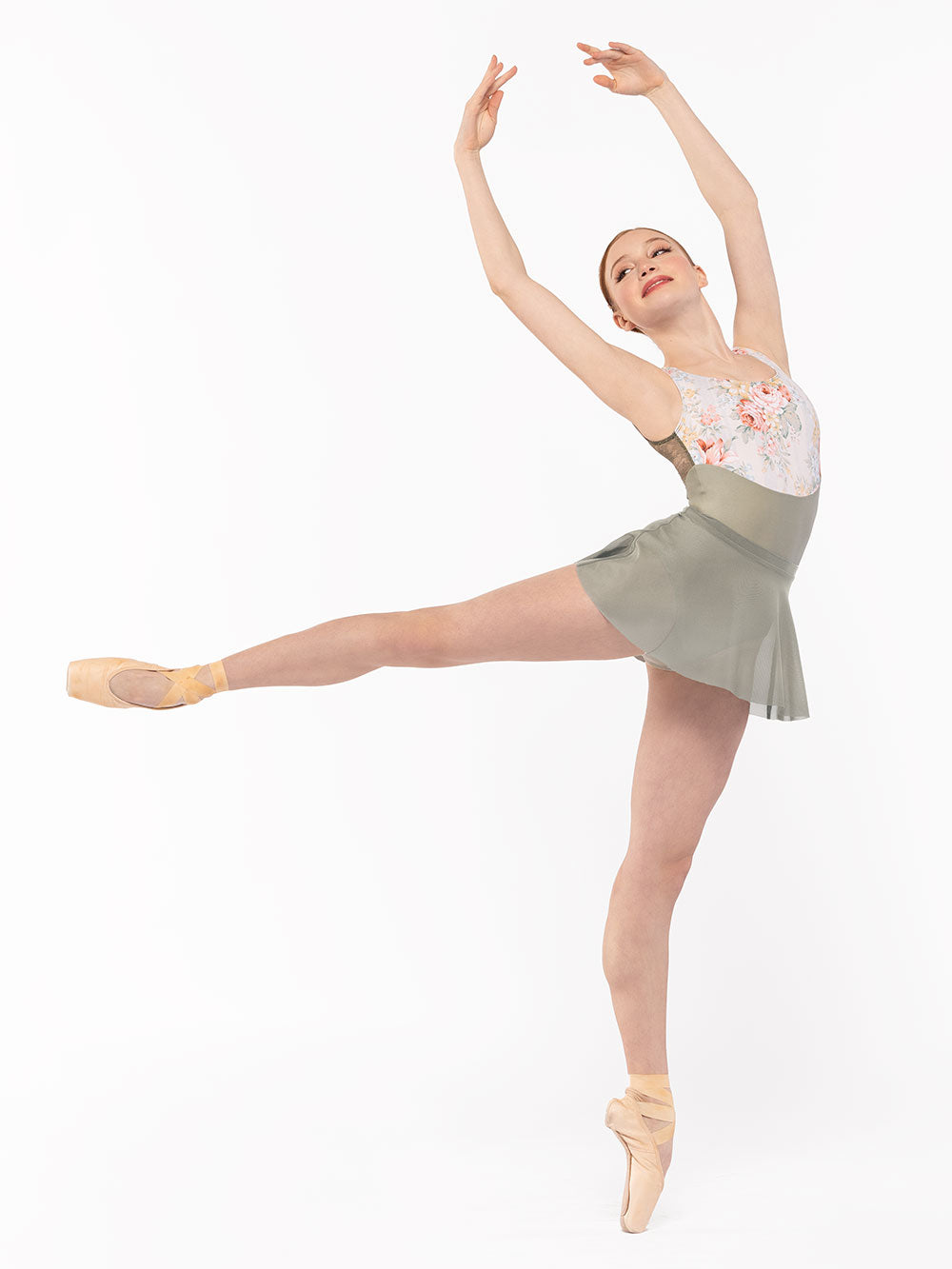 Dancer is facing front but in first high arabesque with both arms on fifth position, wearing a Flare Skirt Mercury Mesh RTW.