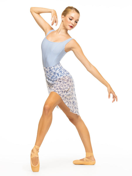 Model is wearing shiny blue tank style bodysuit with corset seams paired with a white and blue floral print mesh skirt.