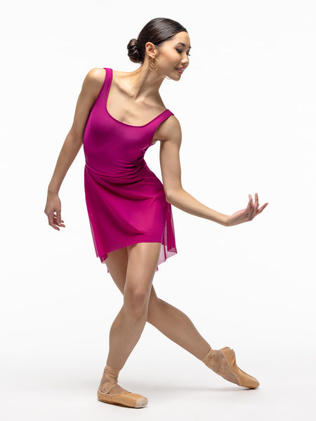 Model is wearing magenta high low mesh skirt with shiny and velvet magenta leotard.