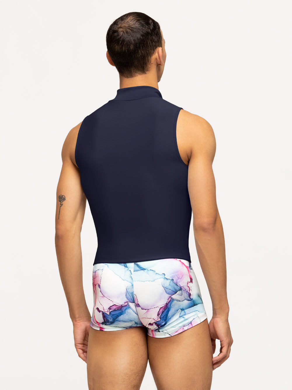 Back of model wearing watercolor print men's bike shorts with navy blue shirt.