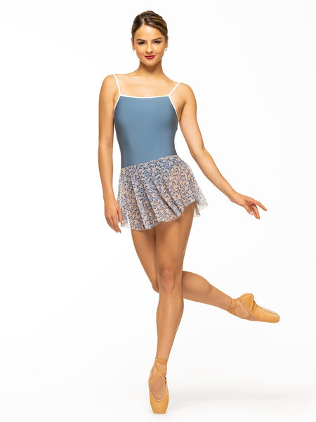Model is wearing shiny denim blue sporty bodysuit with white trim and open back paired with blue floral print mesh full circle mini skirt.