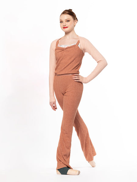 Dancer is facing front with right leg on tendu derriere, wearing a Knit Deven unitard sandstone RTW.