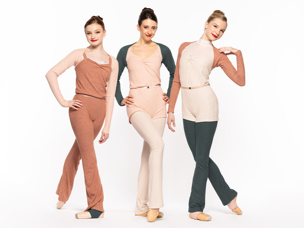 Three dancers facing front and posing, wearing a Knit Deven unitard sandstone RTW.