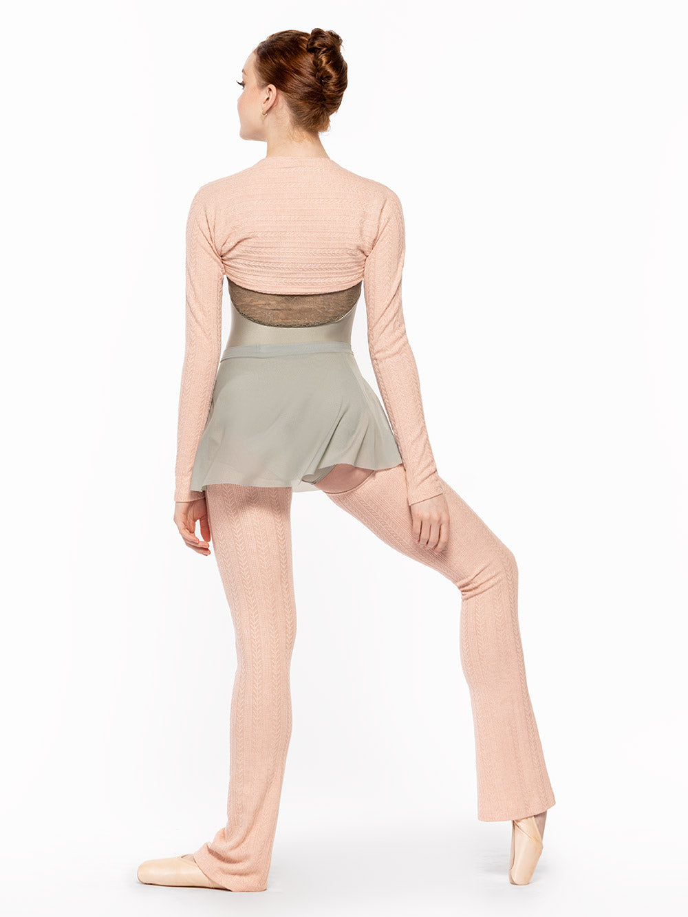 Facing back with one leg a la seconde on point and bend with arms resting down, dancer is wearing a Audrey Leotard Endless Love RTW.