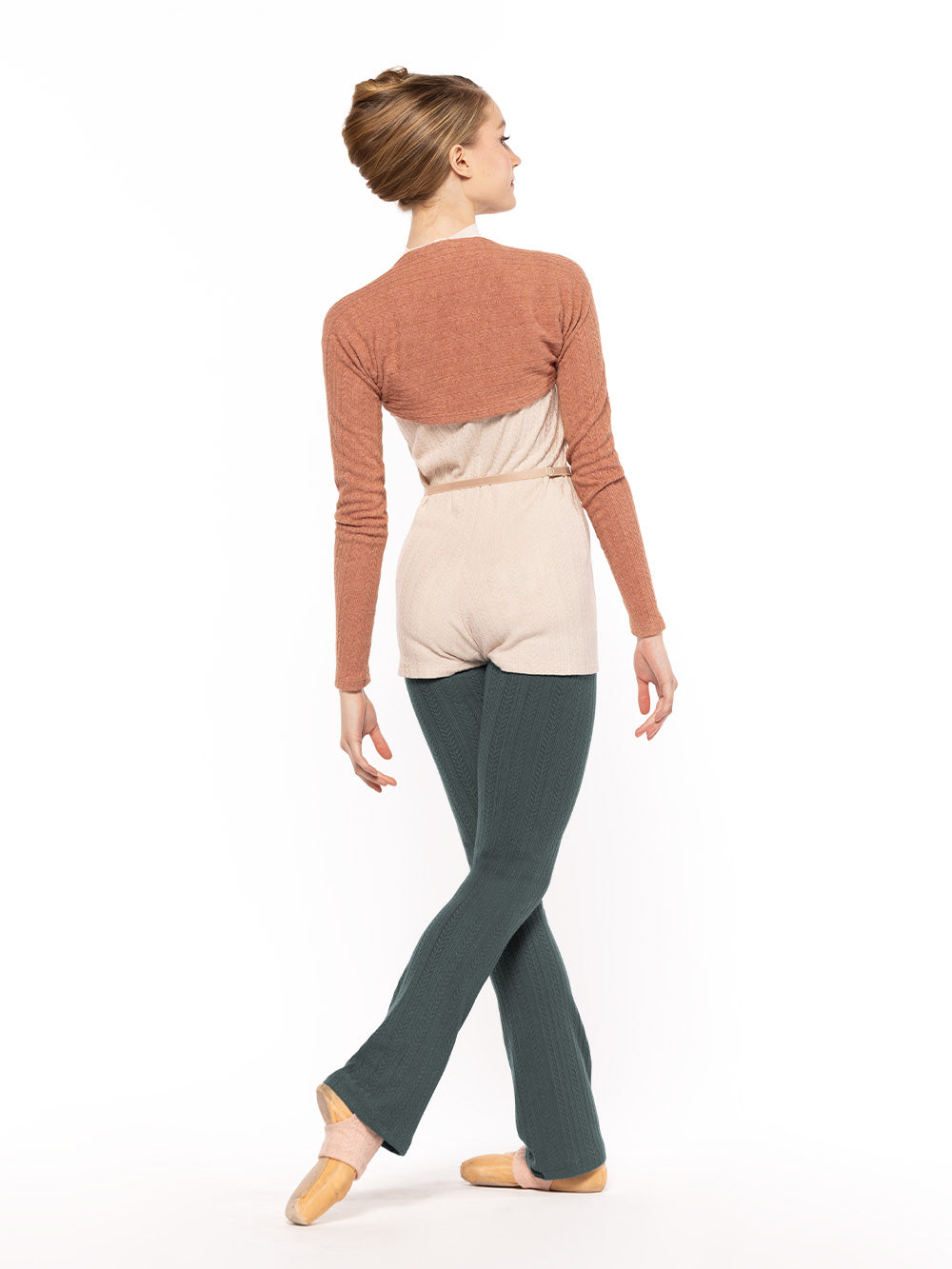 Dancer is facing back with right leg on cou-de-pie back,  wearing a Knit Simone shortie oat RTW.