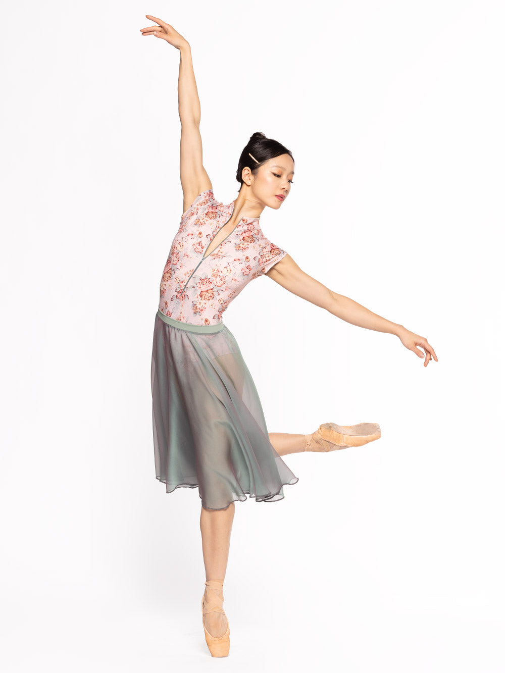 Dancer is on third arabesque doing a small attitude on point, wearing a Molly Leotard Love Letter RTW.