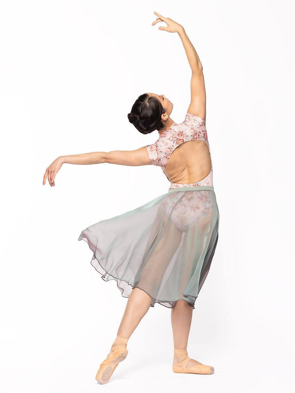 Dancer is facing back but in four arabesques on tendu derriere and arms in fifth and seconde, wearing a Molly Leotard Love Letter RTW.