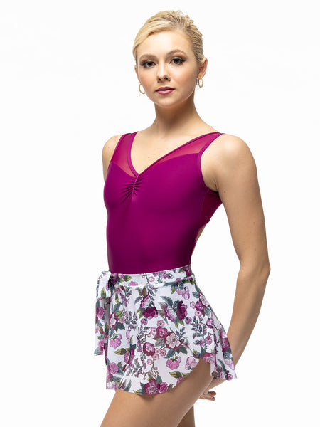 Model is wearing white and magenta floral print mesh skirt with side bow tie and magenta leotard with front pinch.