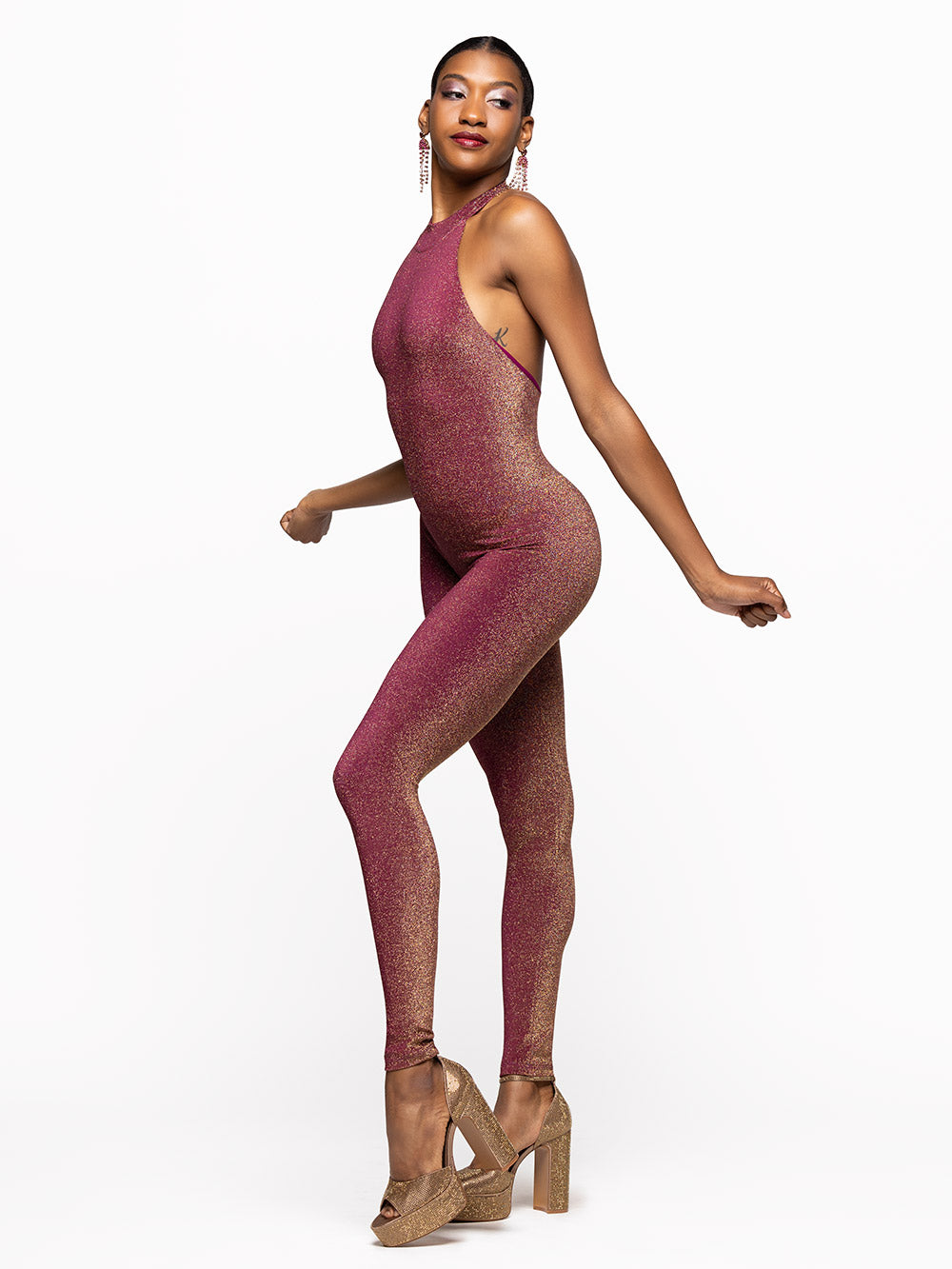 Model is wearing is wearing fuscia onsie with opened back and a collar.
