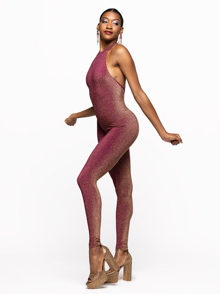 Model is wearing is wearing fuscia onsie with opened back and a collar.