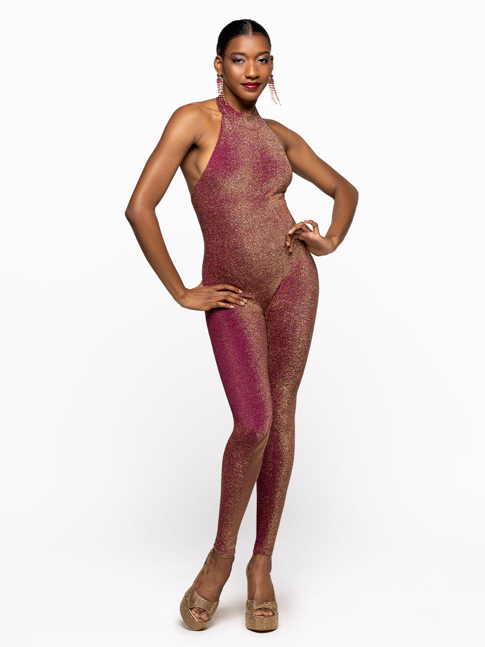 Model is wearing is wearing fuscia onsie with opened back and a collar.