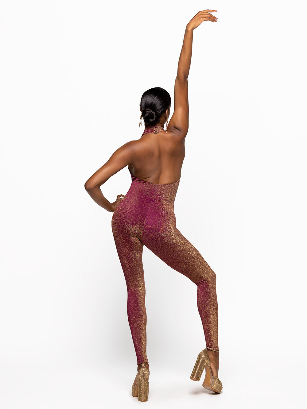 Model is wearing is wearing fuscia onsie with opened back and a collar.