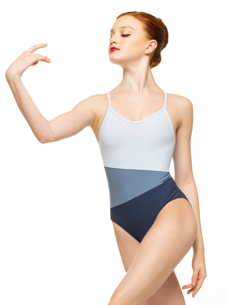 Model is wearing three tone blue bodysuit with asymmetrical panels and a racerback.