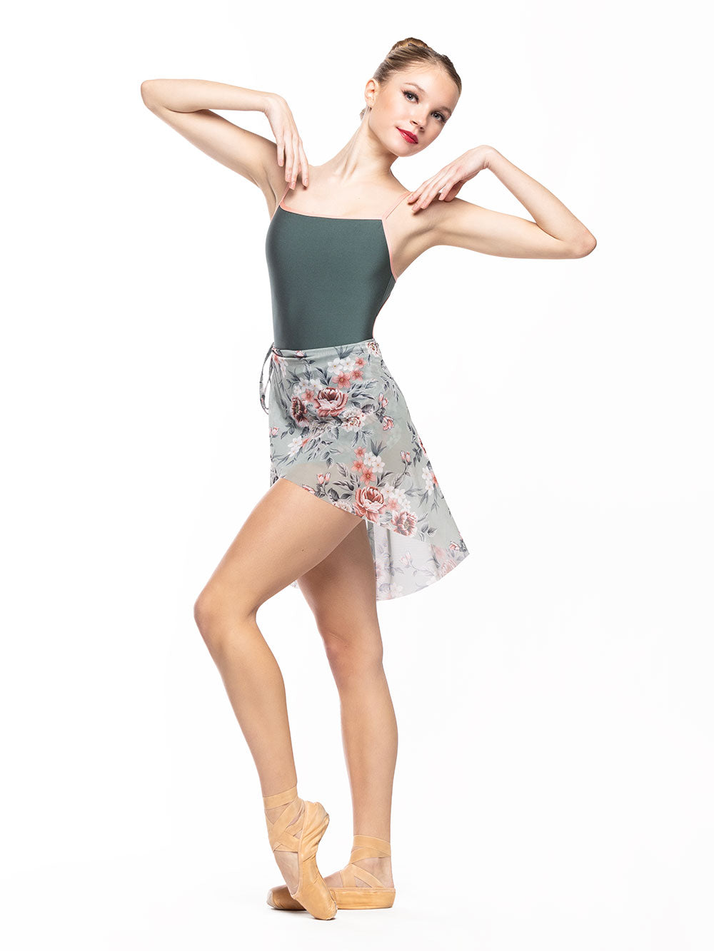 Dancer is facing diagonal front with both arms on the shoulders and one leg crossed on point in cou-de-pie, wearing a Candy Leotard Plate Cacti RTW.