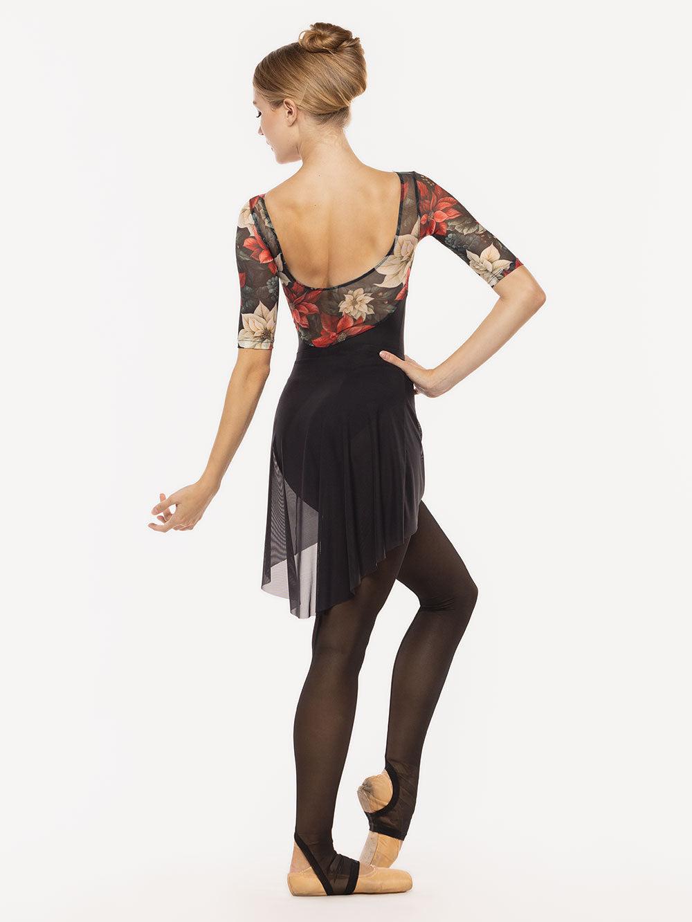 Dancer is facing back with one arm on the hip and the head looking at the other one resting down, one leg on point resting close, wearing a Mid High-Low Skirt Black Mesh RTW.