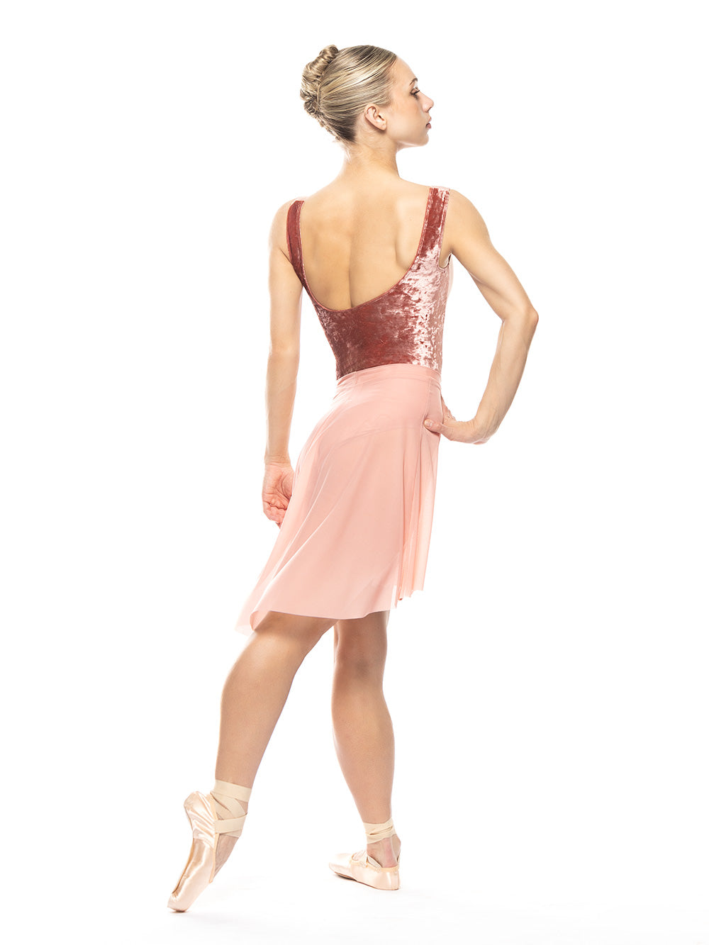 Dancer is showing back detail of the Back Tuck Skirt Rosewater Mesh RTW while on tendu crossed derriere.
