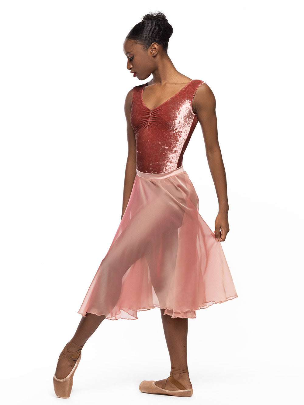 Dancer is facing diagonal front with crossed leg on attitude on the floor on point, wearing a Chiffon Rehearsal Skirt Sandstone RTW.