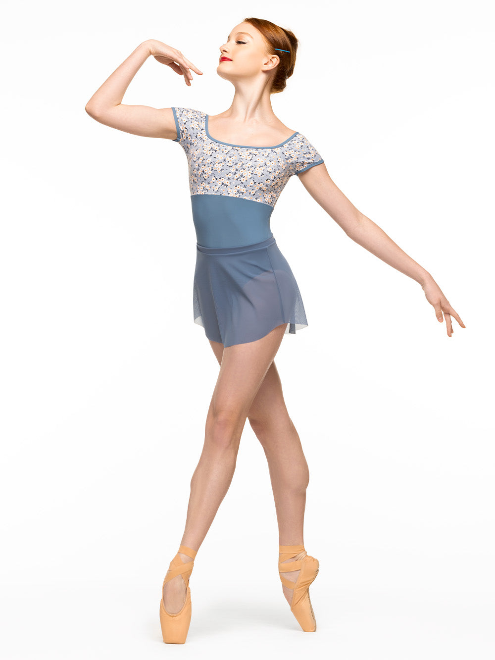 Model is wearing baby blue floral print bodysuit with scoop neck and cap sleeves paired with denim blue mesh mini skirt.