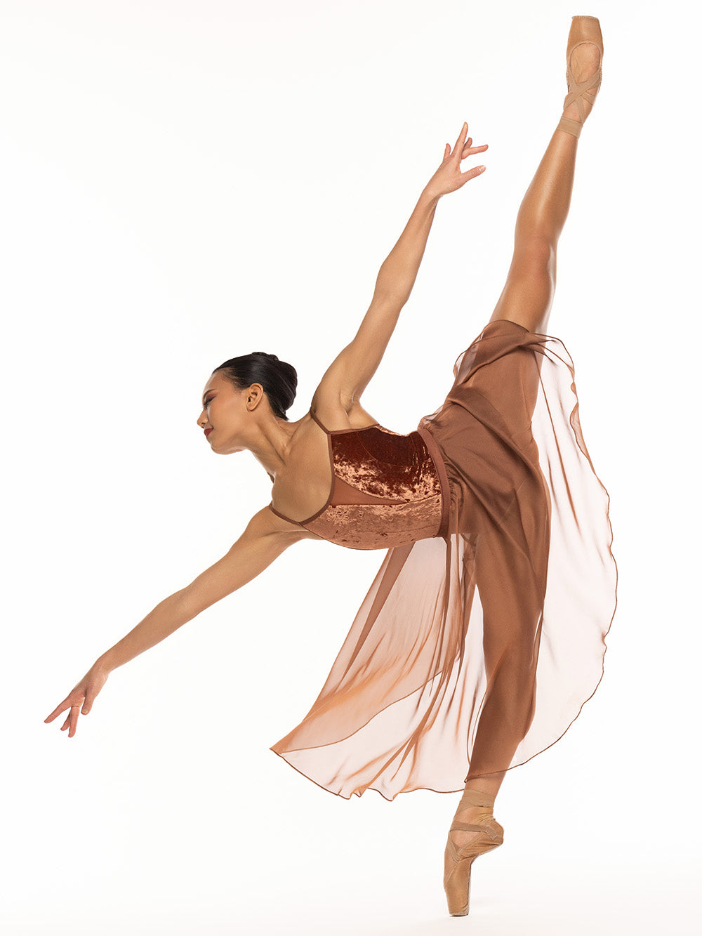 Dancer is in open first arabesque and executing a full penche of 180 degrees, and is wearing a Chiffon Rehearsal Skirt Spice RTW.