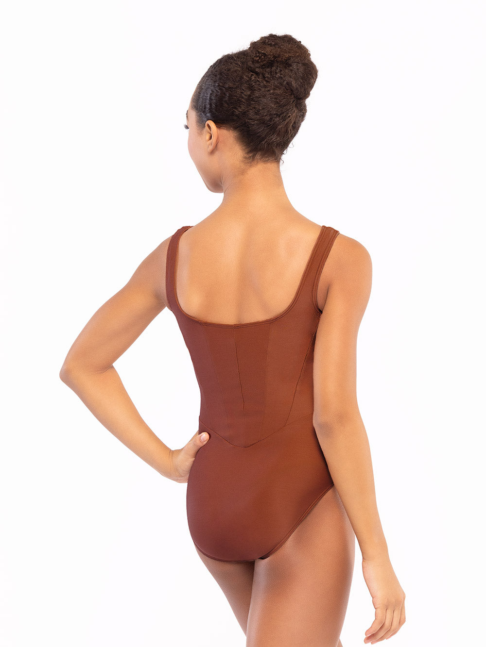 Dancer is facing back with one hand on the hip, wearing a Diana Leotard Spice RTW.