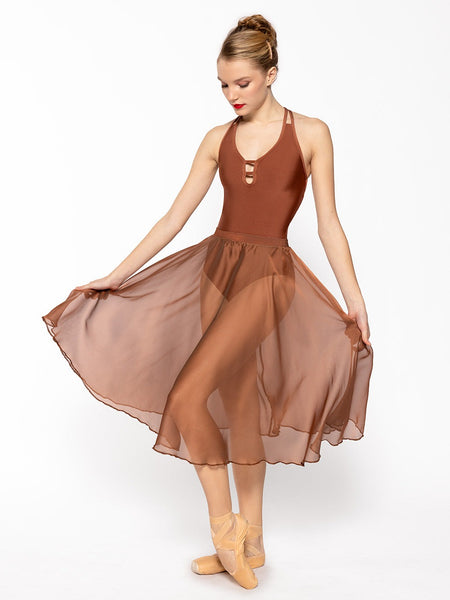 Dancer is facing front with one leg resting on point holding the skirt side by side, wearing a Chiffon Rehearsal Skirt Spice RTW.