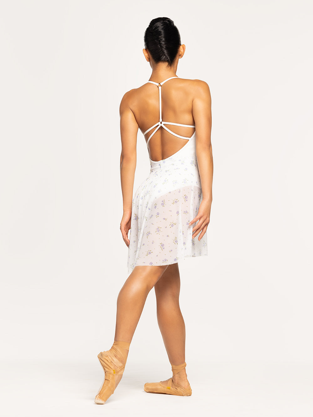 Eleve Dancewear Long High-Low Skirt in Baby's Breath print Mesh, back view with dancer showing a tendu croise derriere.