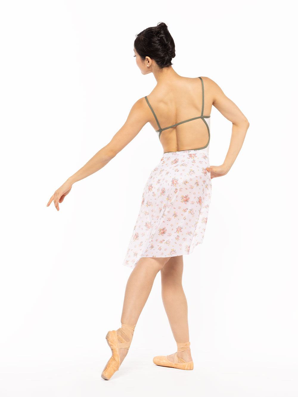 Dancer is facing back on tendu crossed derriere and one arm on the hip, wearing a Candy Leotard Cream RTW.