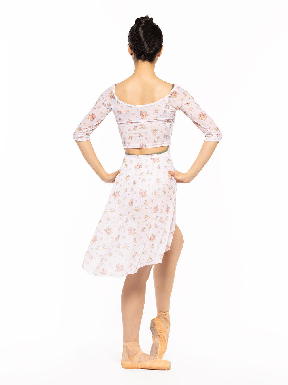 Dancer is facing back with both hands on the hips and one leg in front resting on point, wearing a Candy Leotard Cream RTW.