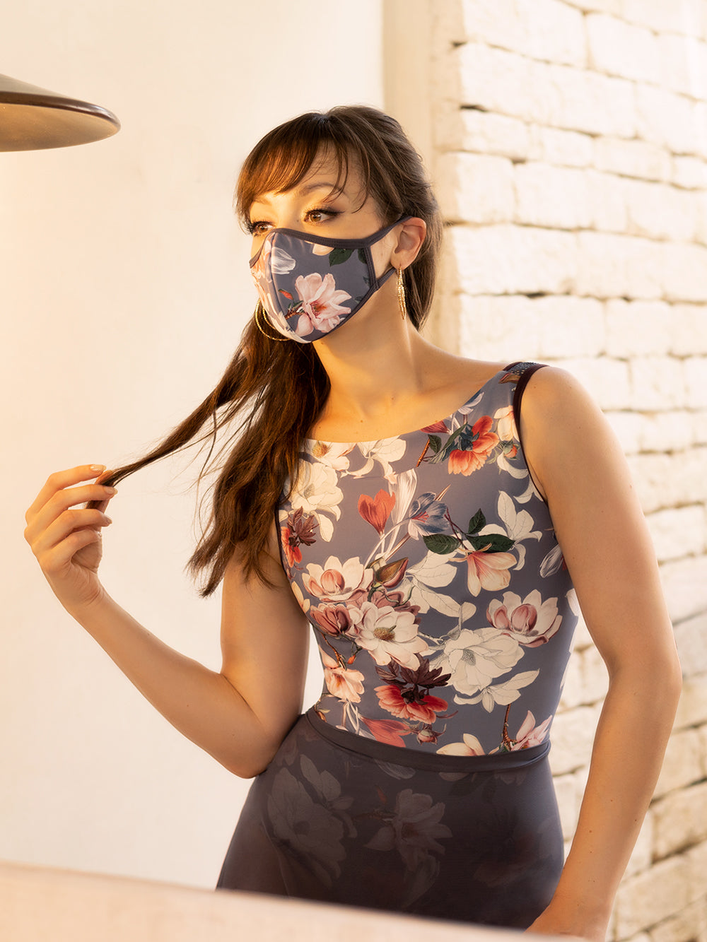 Model wearing a floral pattern leotard with a matching dark purple mesh skirt